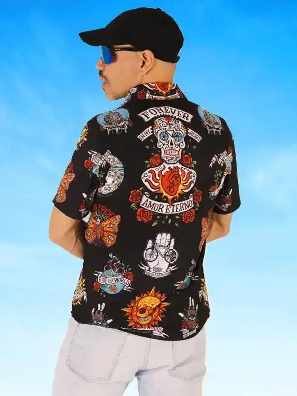 Men's black cycling shirt with colorful skull, butterfly, and rose tattoo-style print, worn outdoors