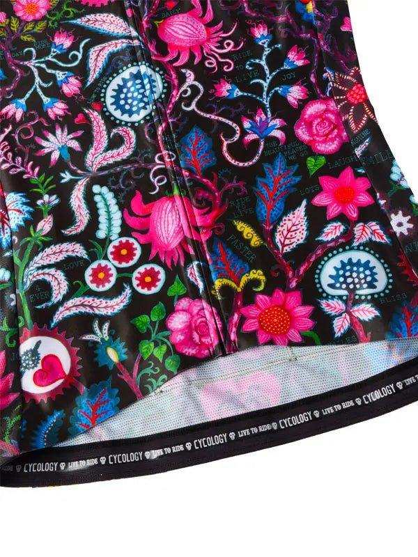 Vibrant floral cycling jersey with pink, blue, and green patterns on black fabric, featuring Cycology branding on hem.