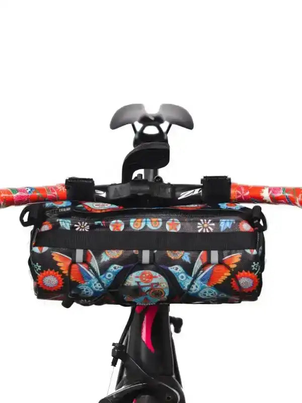 Colorful patterned bike handlebar bag with floral and skull designs, mounted on cycling handlebars