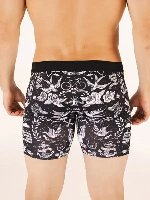 Men's cycling shorts with tattoo-style swallow, rose, and bike print on black fabric
