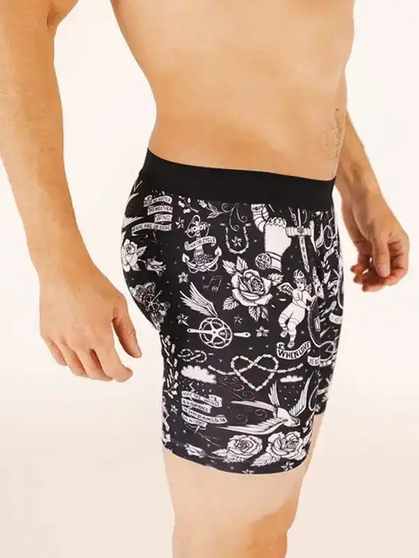 Men's cycling shorts with black and white tattoo-style print, featuring roses, anchors, and vintage motifs.