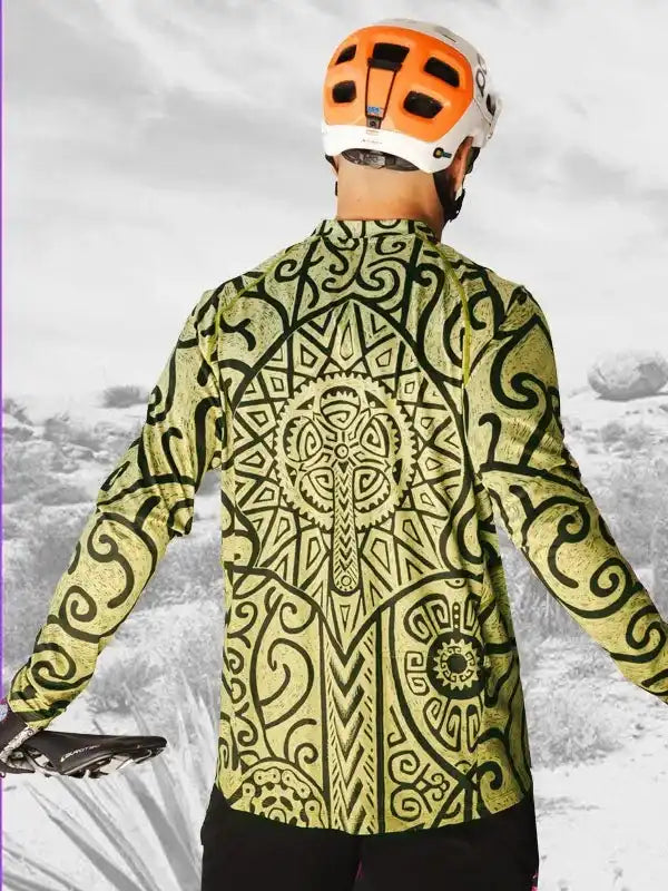 Men's cycling jersey with bold tribal print, worn with orange helmet on trail