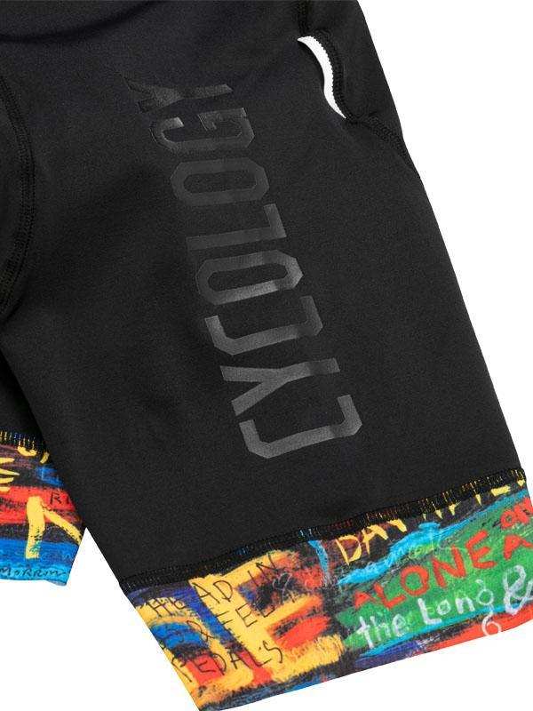 Black cycling shorts with bold 'CYCOLOGY' print and colorful graffiti-style hem design