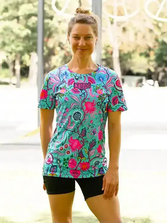 Woman wearing vibrant floral cycling jersey and black shorts outdoors