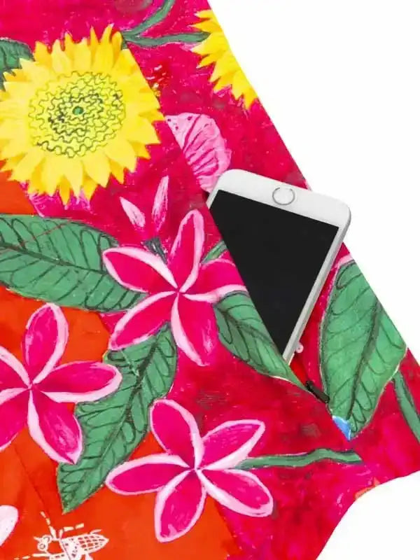 Vibrant floral cycling jersey pocket holding smartphone, featuring sunflowers and plumeria on bold pink and orange fabric.