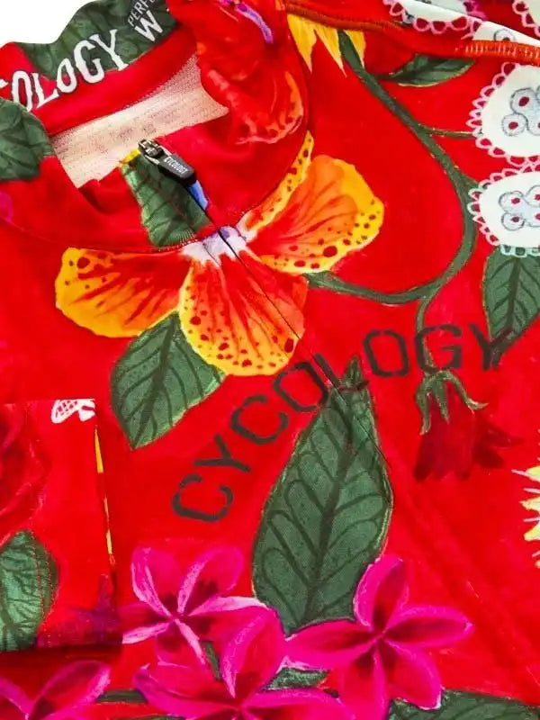 Vibrant red women's cycling jersey with tropical floral print and 'CYCOLOGY' branding