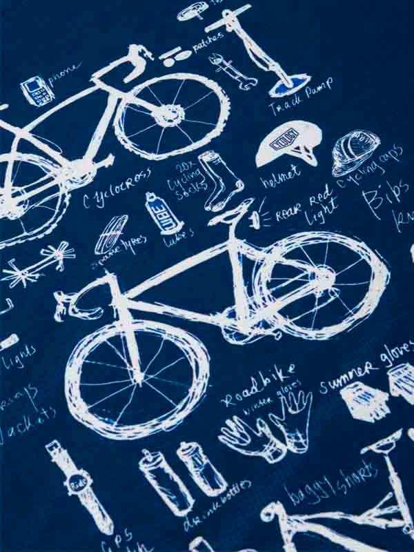 Cycling apparel design with bikes, helmets, gloves, and gear sketches on navy fabric