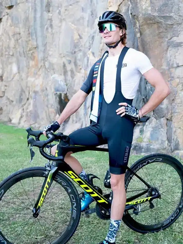 Man in cycling bib shorts and jersey posing with Scott road bike outdoors