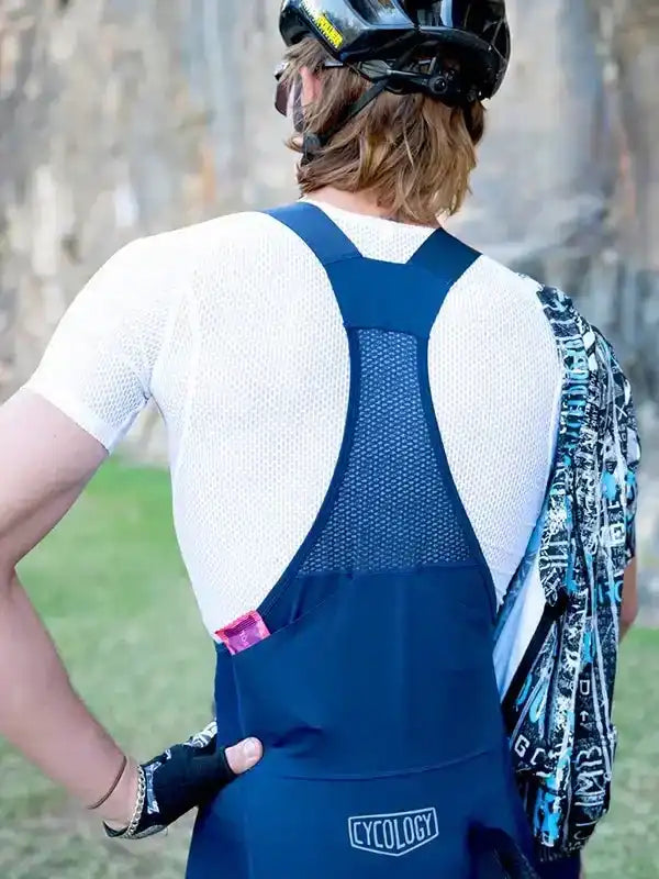 Men's cycling bib shorts with mesh back panel, worn with white jersey and helmet, ideal for road biking comfort.
