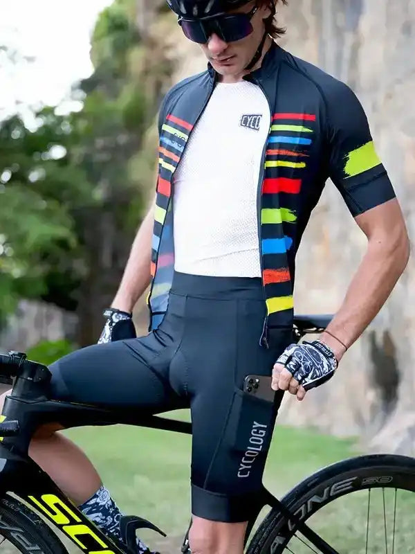 Man in colorful cycling jersey and black shorts, riding bike outdoors
