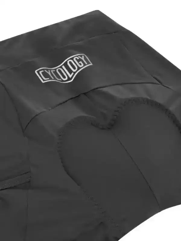 Black cycling shorts with padded seat and CYCOLOGY logo, designed for comfort and performance.