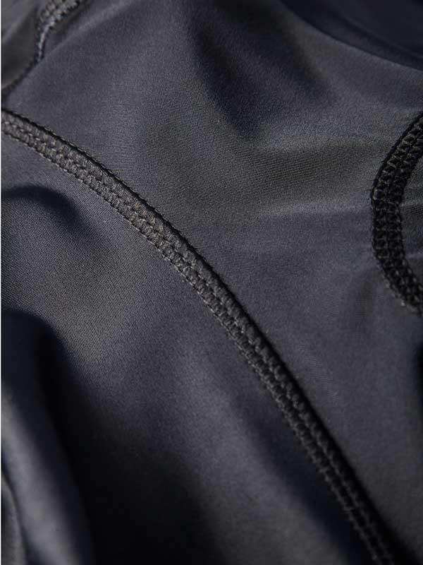 Close-up of dark cycling jersey fabric with flatlock seams and breathable mesh panel