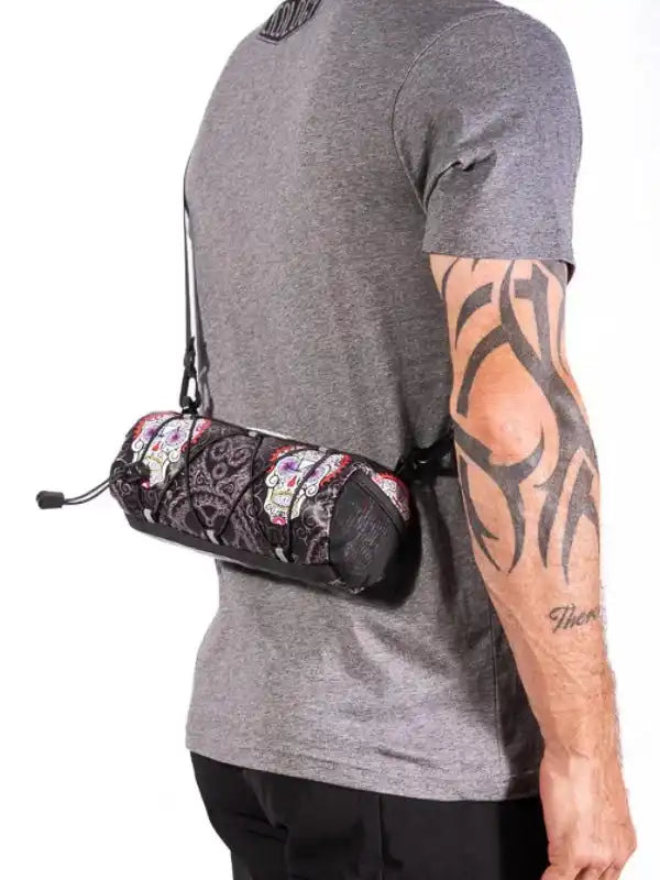 Cycling waist bag with sugar skull print, worn by man with tattooed arm, ideal for bike rides