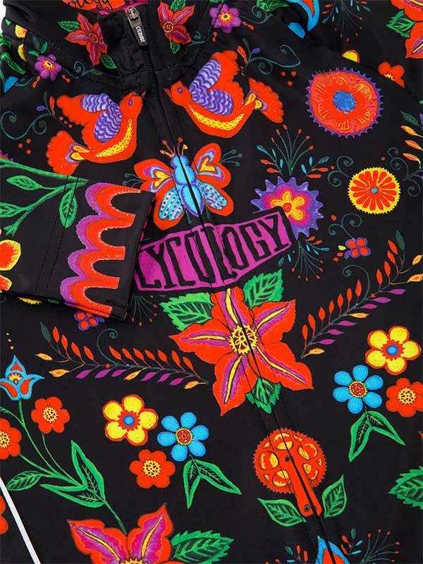 Vibrant floral and bird print cycling jersey with bold colors and 'CYCOLOGY' logo on black fabric