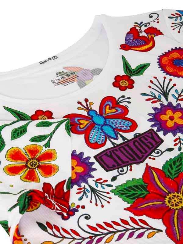 White cycling jersey with vibrant floral and butterfly embroidery, featuring bold colors and detailed patterns.
