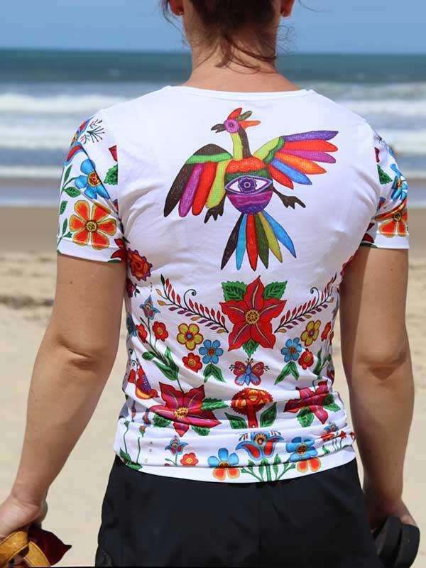 Women's cycling jersey with colorful floral and bird print, worn on beach