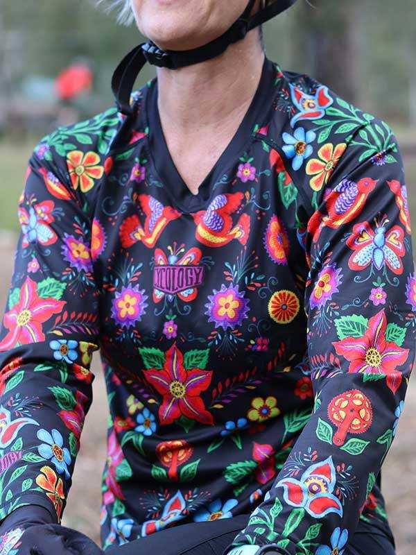 Women's cycling jersey with vibrant floral and bird print, long sleeves, V-neck design for outdoor rides