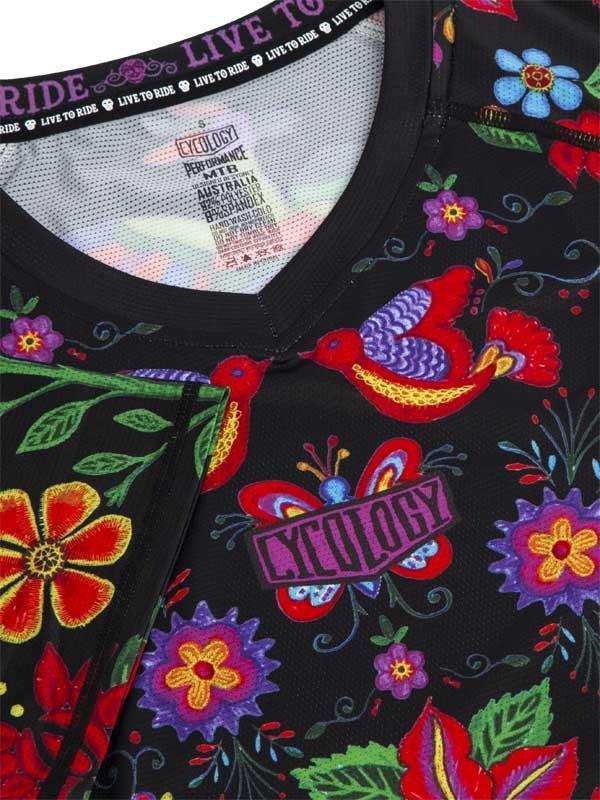 Vibrant floral and bird print cycling jersey with colorful embroidery and 'Live to Ride' neck tag