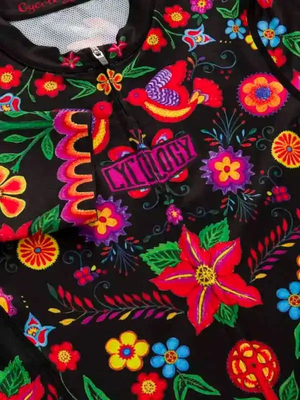 Vibrant floral and bird pattern on black cycling jersey with bold 'CYCOLOGY' logo