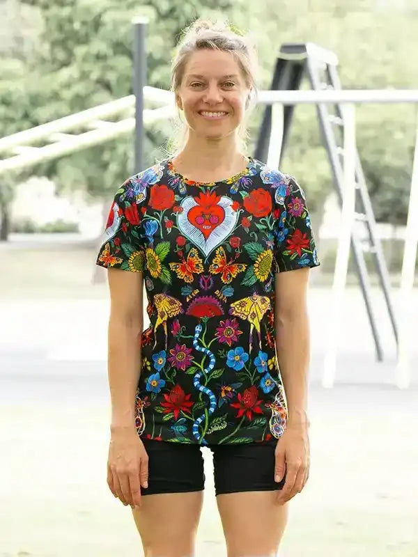 Woman wearing colorful floral cycling jersey with heart design, paired with black shorts for outdoor rides
