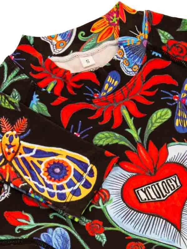 Women's cycling jersey with vibrant floral and butterfly print, featuring bold reds and blues on black fabric.
