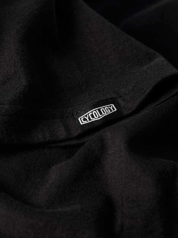 Black cycling jersey with white Cycology logo tag, high-quality fabric detail