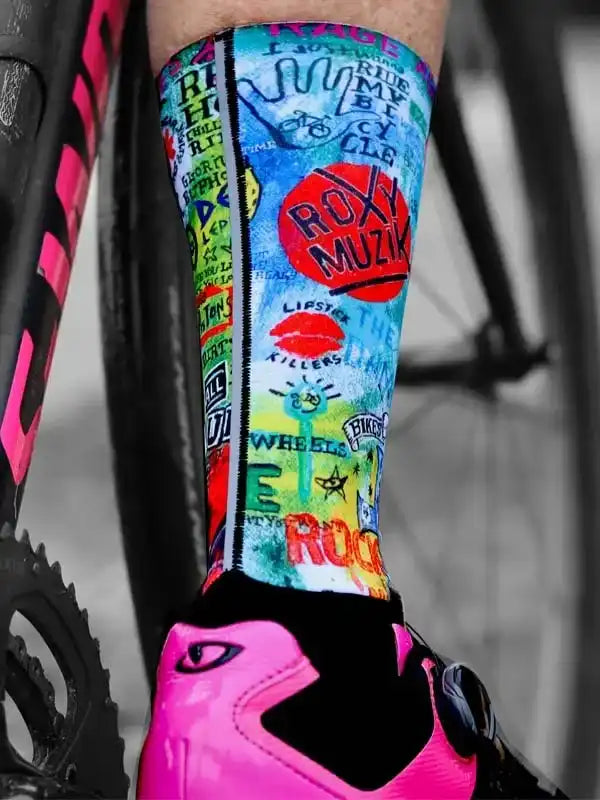 Colorful graffiti-style cycling socks with bold graphics, paired with pink cycling shoes and bike frame