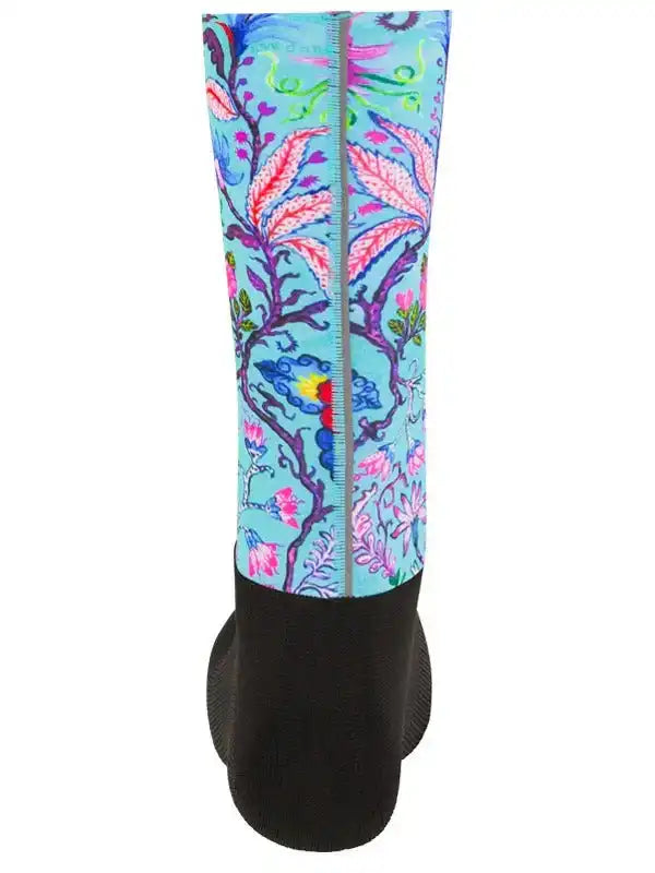 Colorful floral cycling arm warmers with vibrant leaf pattern on light blue background