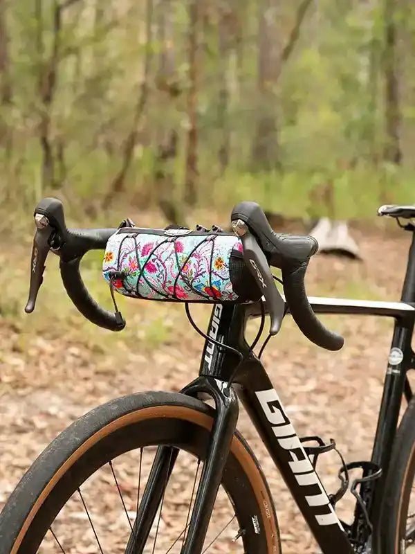 Floral cycling handlebar bag on road bike in forest, ideal for bikepacking and outdoor rides