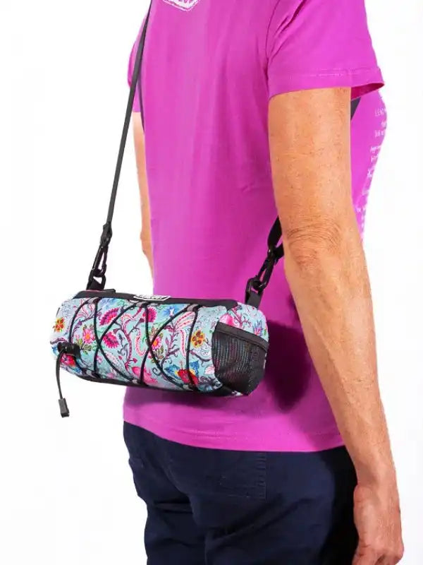 Colorful floral cycling waist bag with mesh pocket, worn crossbody by cyclist in pink tee