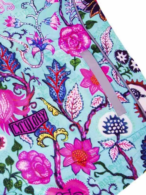 Vibrant floral cycling jersey with pink and blue botanical print, featuring a zipper and brand tag.