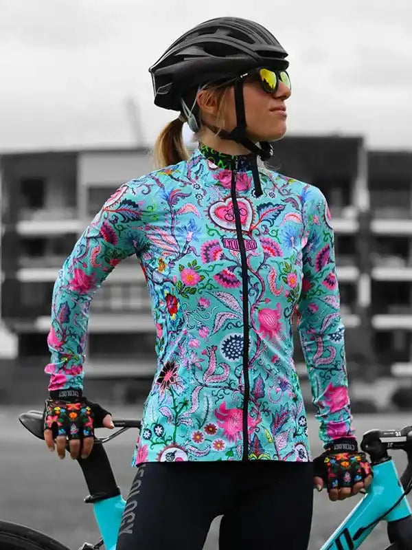 Woman in vibrant floral cycling jersey, helmet, and gloves, ready to ride