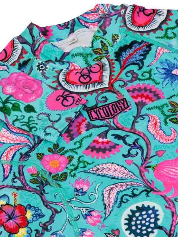 Vibrant floral cycling jersey with pink hearts, hibiscus, and bike motifs on teal fabric