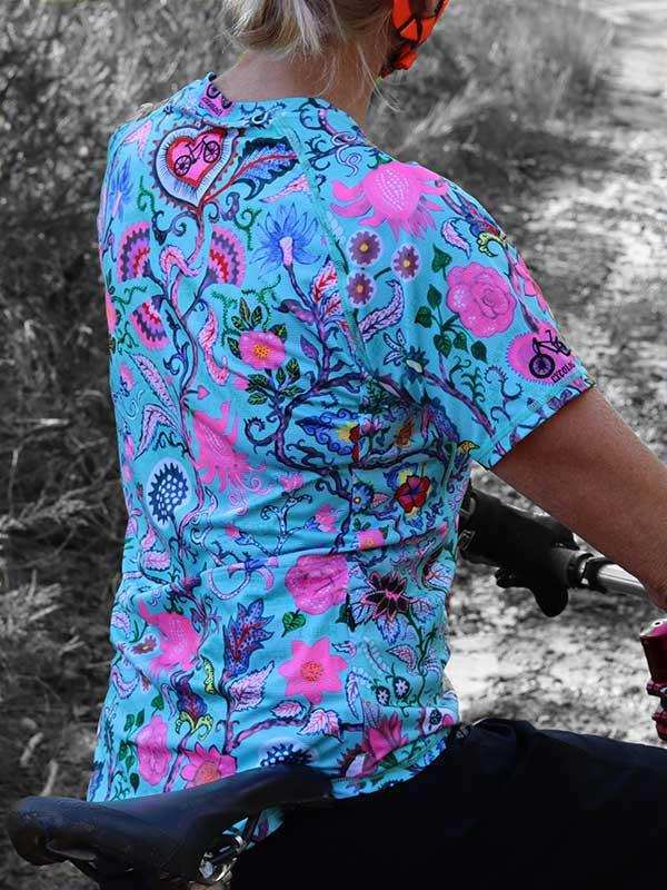 Woman cycling in vibrant floral print jersey, ideal for road or trail rides