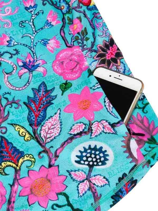 Vibrant floral cycling jersey pocket holding smartphone, featuring pink flowers and teal fabric design