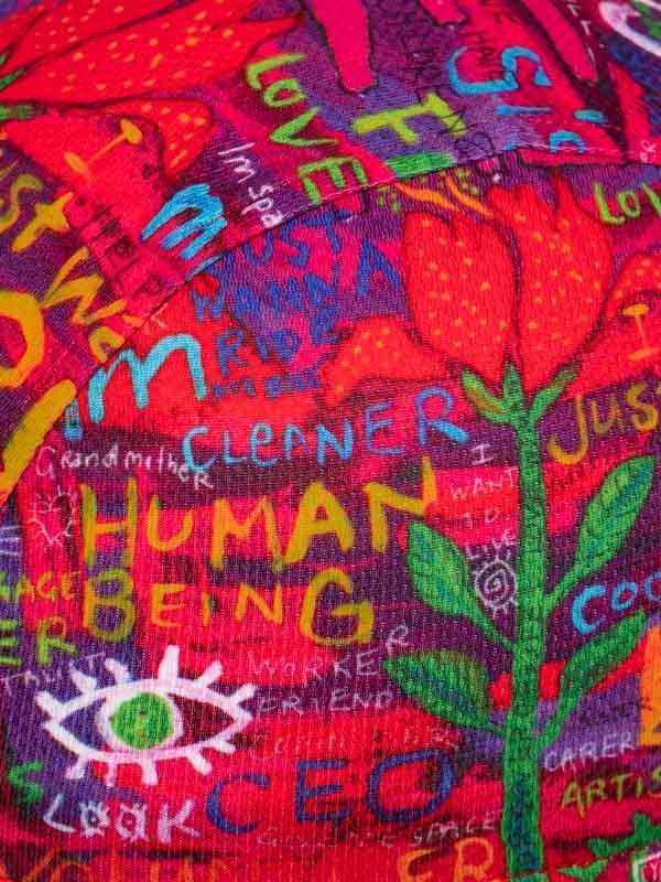 Vibrant cycling jersey with bold 'HUMAN BEING' print, colorful graffiti-style art, and floral design for road biking.