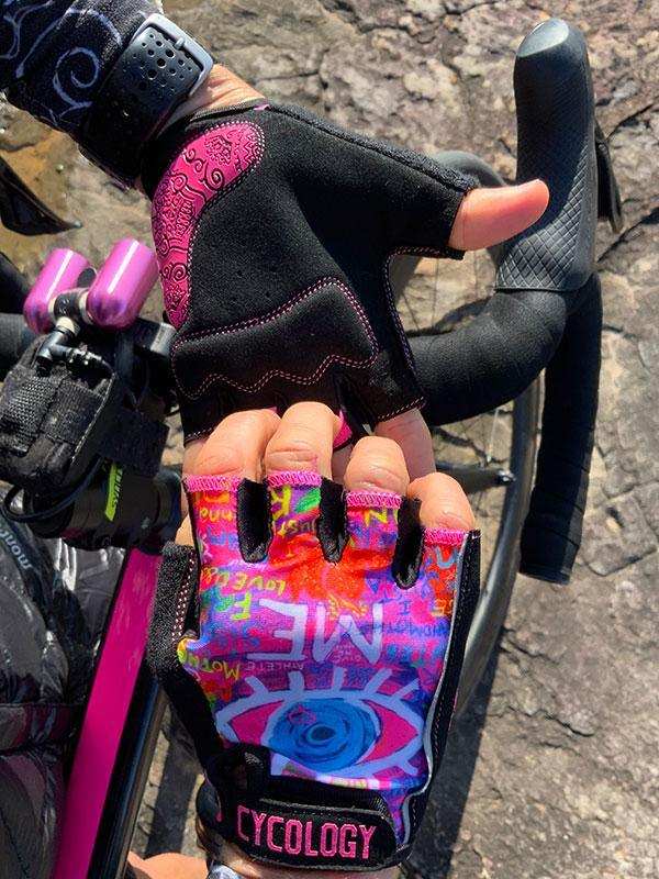 Colorful fingerless cycling gloves with eye design, worn on bike handlebars