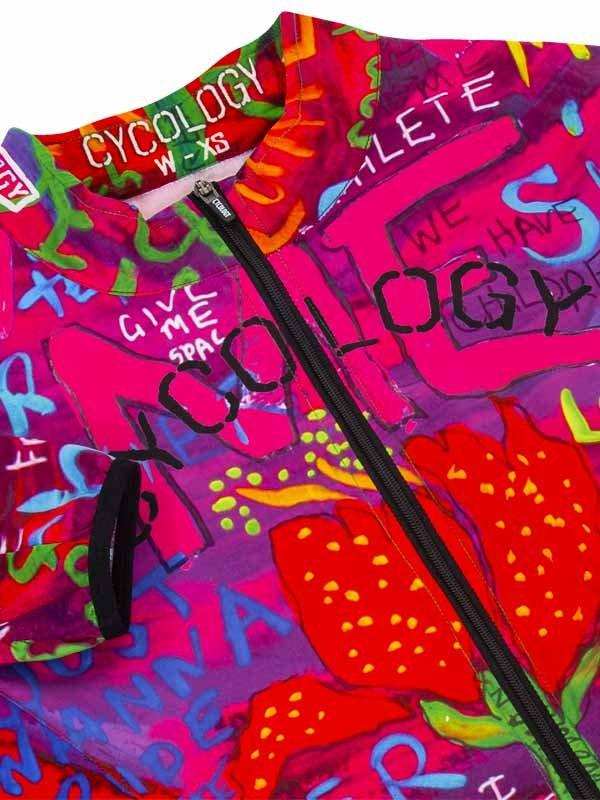 Vibrant pink cycling jersey with bold graffiti-style graphics, strawberries, and 'Cycology' text, women's XS size