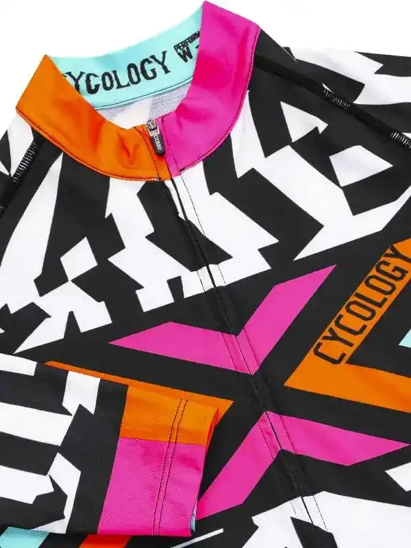 Vibrant cycling jersey with bold black, white, pink, and orange geometric design, featuring zipper and brand text.