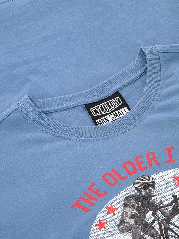 Light blue cycling t-shirt with 'The Older I' graphic, cyclist print, and red stars. Men's small size tag visible.