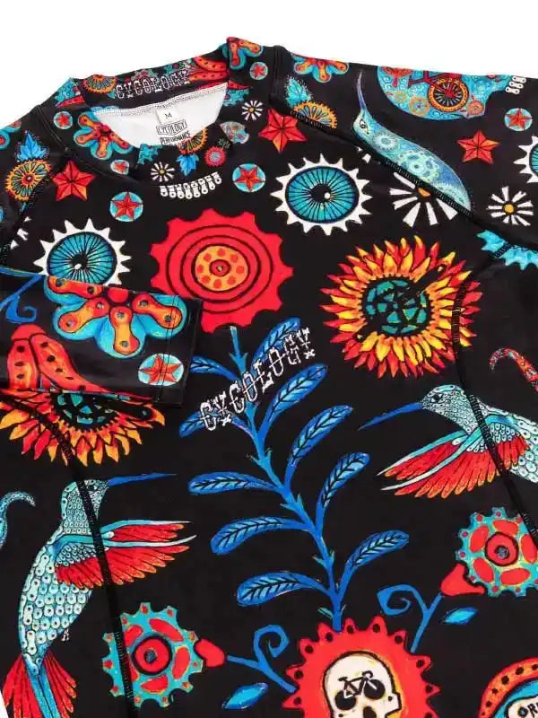 Men's cycling jersey with vibrant floral and hummingbird print on black fabric, featuring bold red, blue, and orange designs.