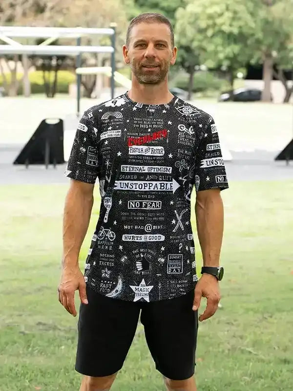 Man wearing black graphic cycling jersey with motivational quotes and bike icons, ideal for road or mountain biking.