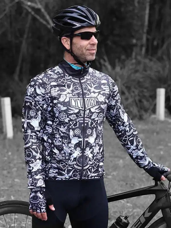 Man in black and white patterned cycling jersey with helmet, outdoors near bike