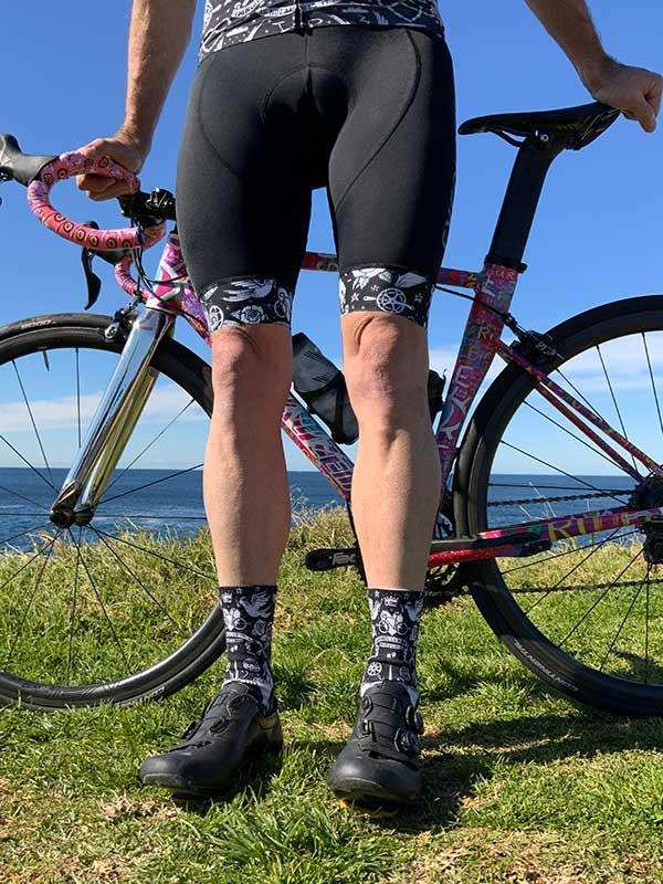 Men's cycling shorts and patterned socks with road bike by ocean, ideal for cycling apparel